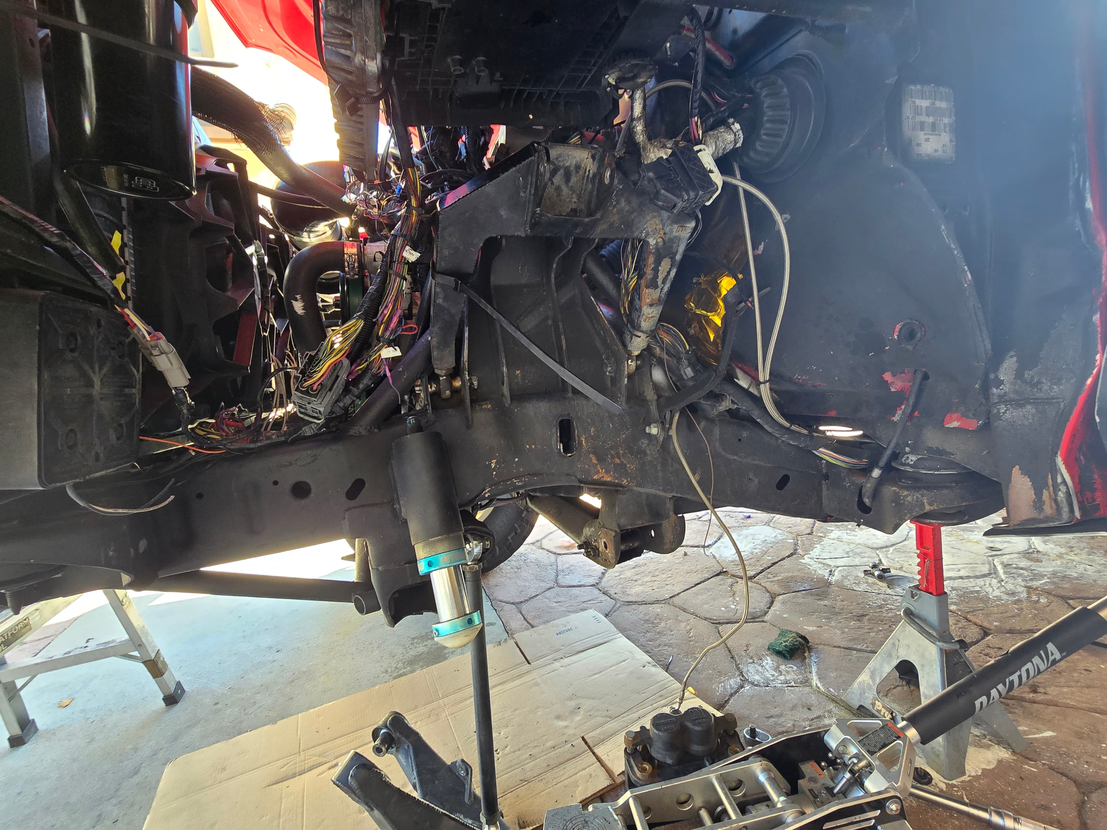 The exposed driver-side front rail of the founder's 2015 GMC Sierra during teardown